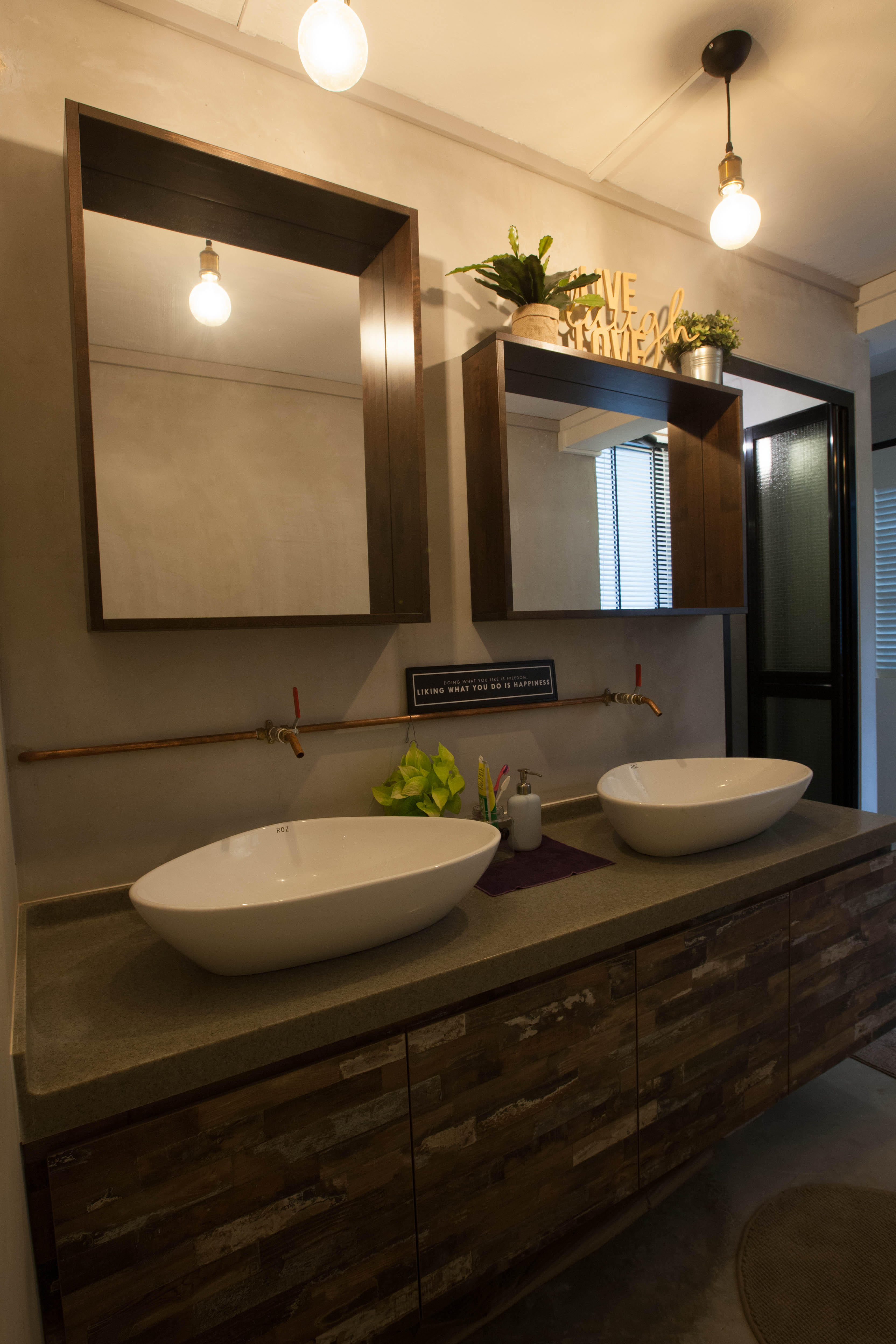 Industrial-style bathroom with dual vessel basins, exposed copper fixtures, and rustic wood vanity
